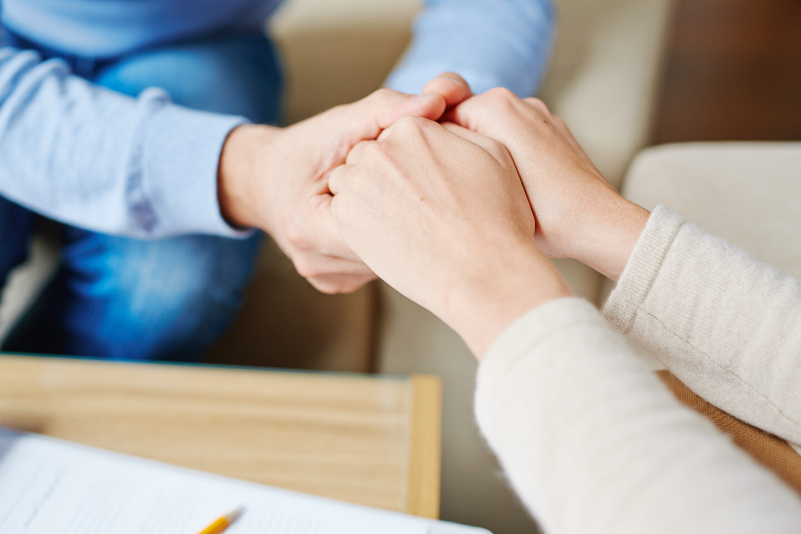 Close-up of psychiatrist hands in those of patient